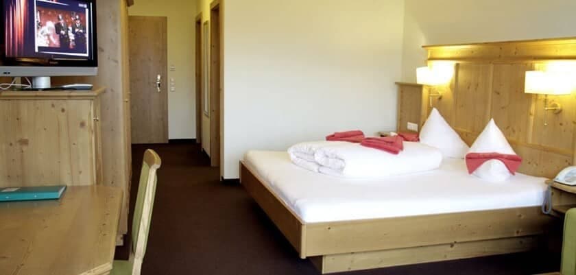 Guest bedroom with king bed, wall-mounted reading lights, and flat-screen TV