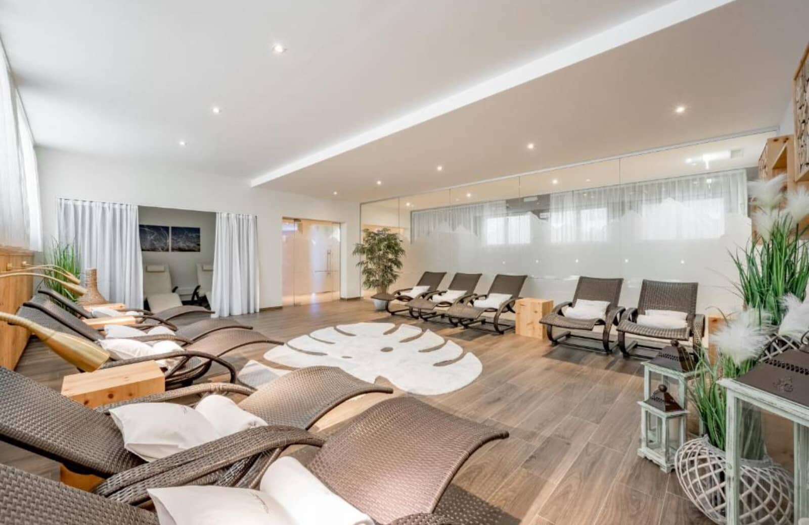 Spa relaxation lounge with 10 recliners and glass-walled sauna entrance