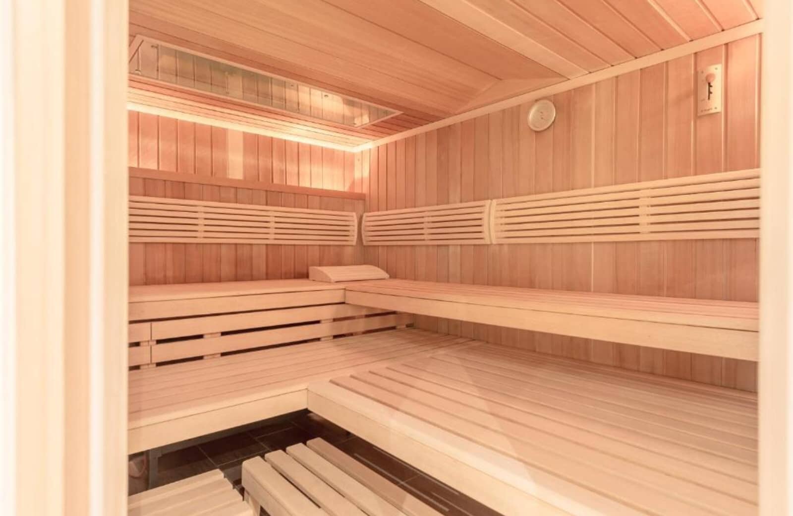 Private cedar sauna with multi-level bench seating for six