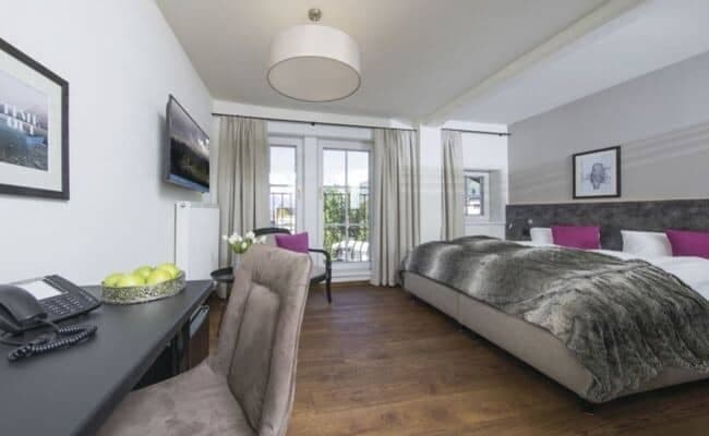 Guest bedroom with king bed, work desk, and balcony access