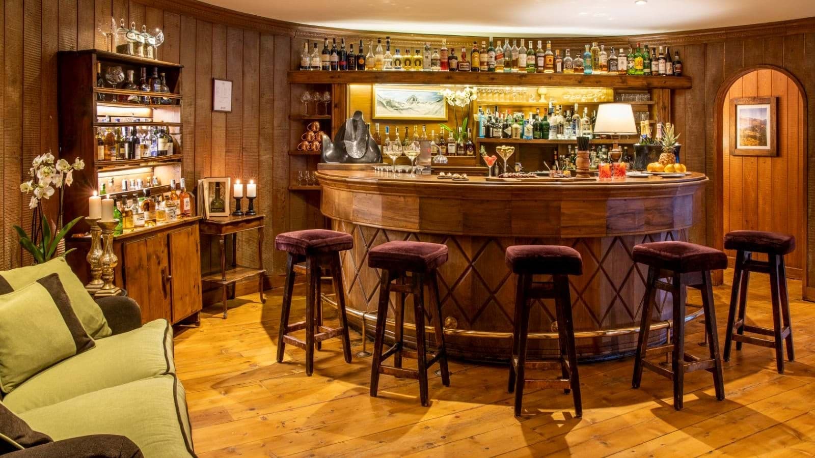 Wood-paneled bar with seating for 5 and extensive liquor collection