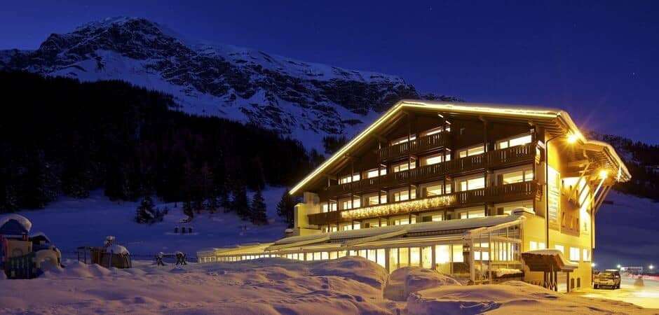 Ski-in/ski-out lodge at night; mountain views and heated terrace