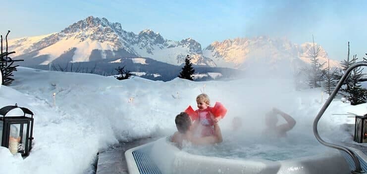 Outdoor sunken hot tub with panoramic mountain range views