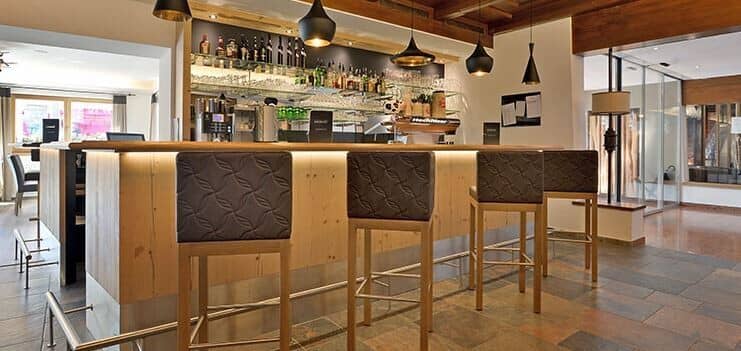 Bar area with professional espresso machine and seating for four