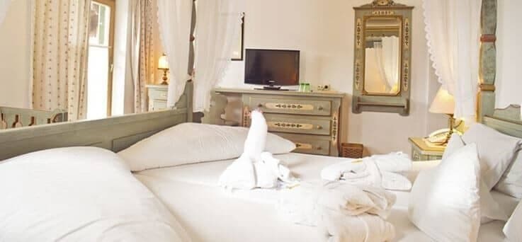 Bedroom with canopy bed and hand-painted dresser with TV