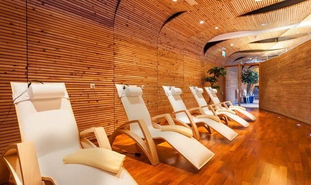 Spa relaxation room featuring five ergonomic wooden loungers