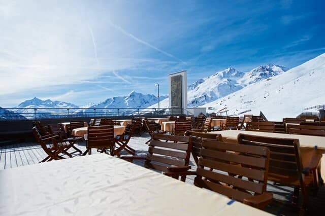 Outdoor dining deck with panoramic alpine views and group seating
