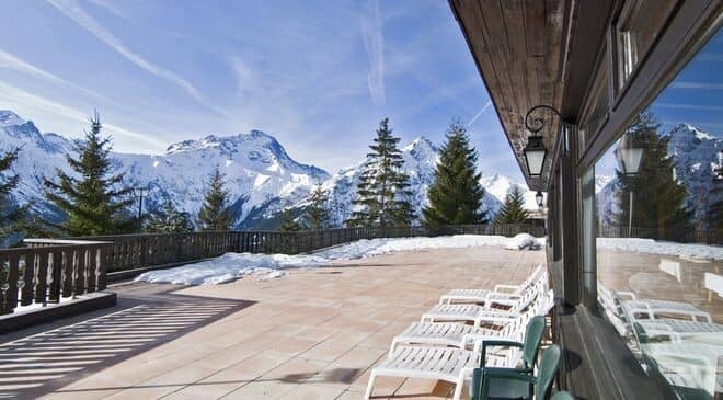 Stone sun terrace with loungers and panoramic mountain views