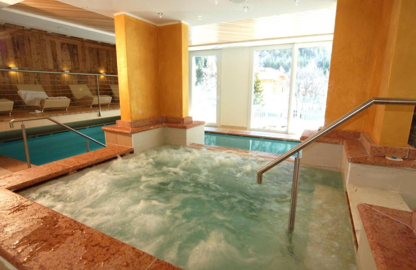 Indoor hot tub and lap pool with mountain views and lounge seating