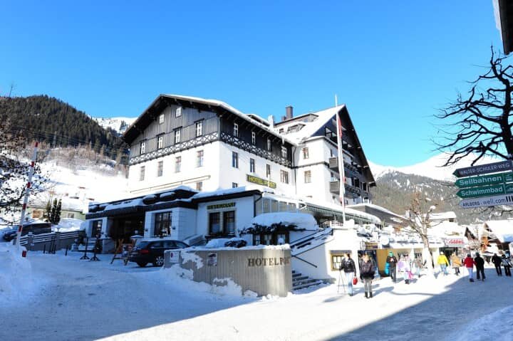 Hotel exterior with nearby ski lift and swimming pool directional signage