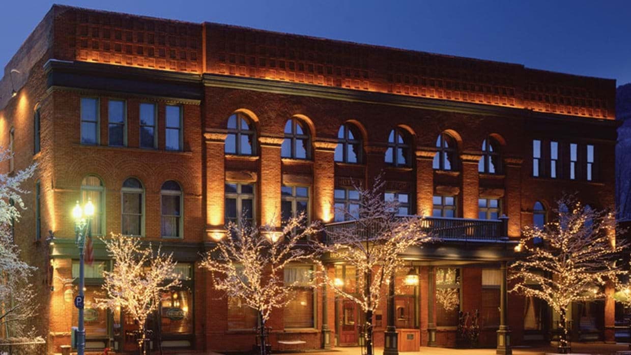 Historic red brick exterior featuring original arched windows and second-story balcony