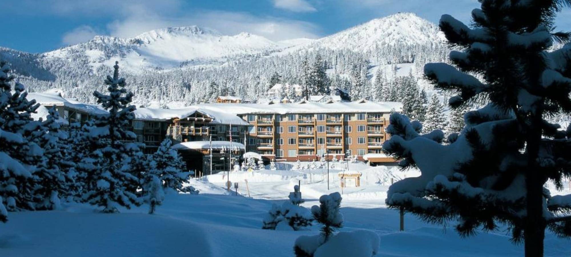 Resort exterior featuring private balconies and mountain backdrop