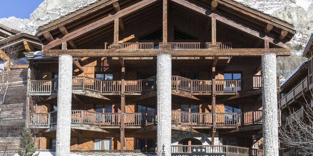 Timber chalet exterior with private balconies and mountain backdrop