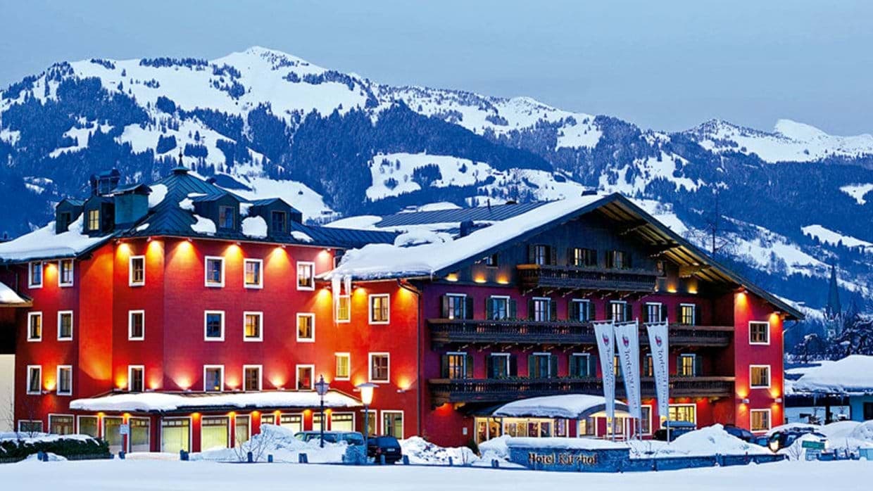 Hotel exterior at twilight with snow-covered mountain views