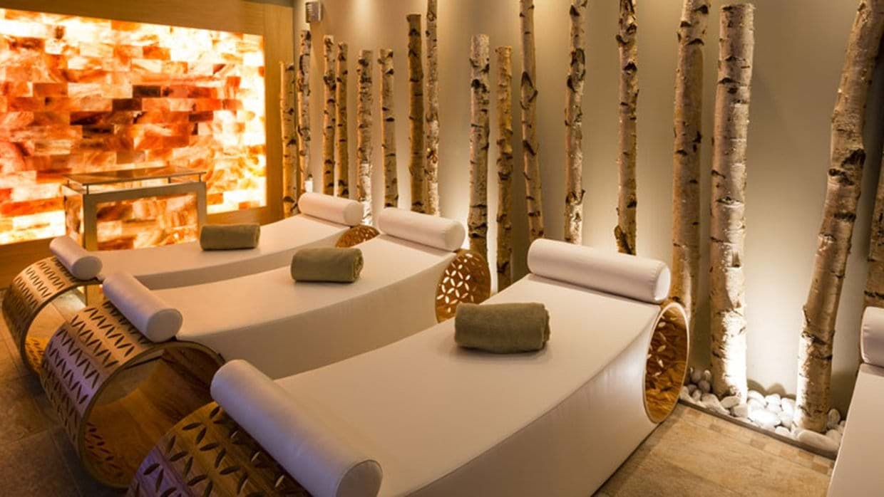 Spa lounge with ergonomic heated loungers and Himalayan salt wall