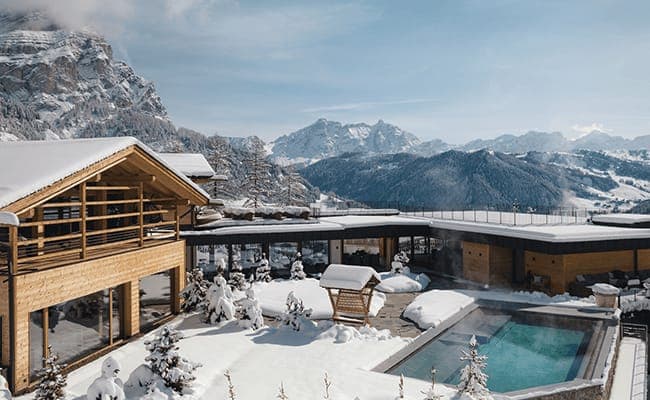 Chalet courtyard with heated outdoor pool and panoramic dolomite views