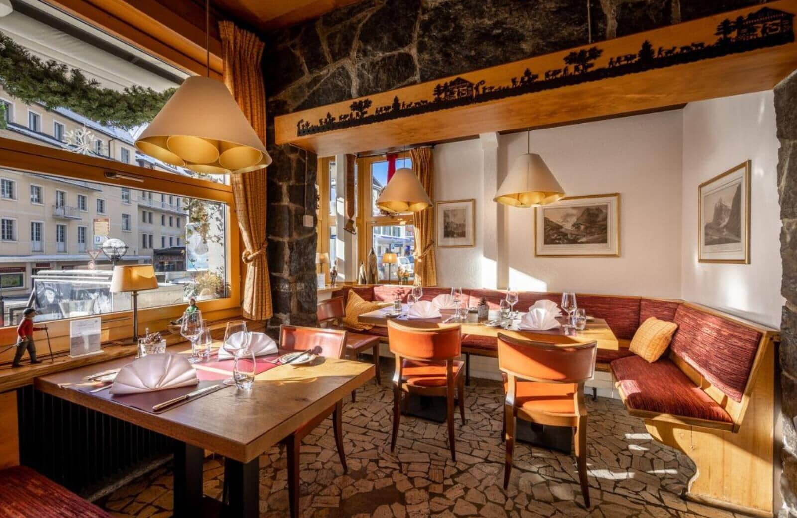 Dining area with banquette seating and village street views