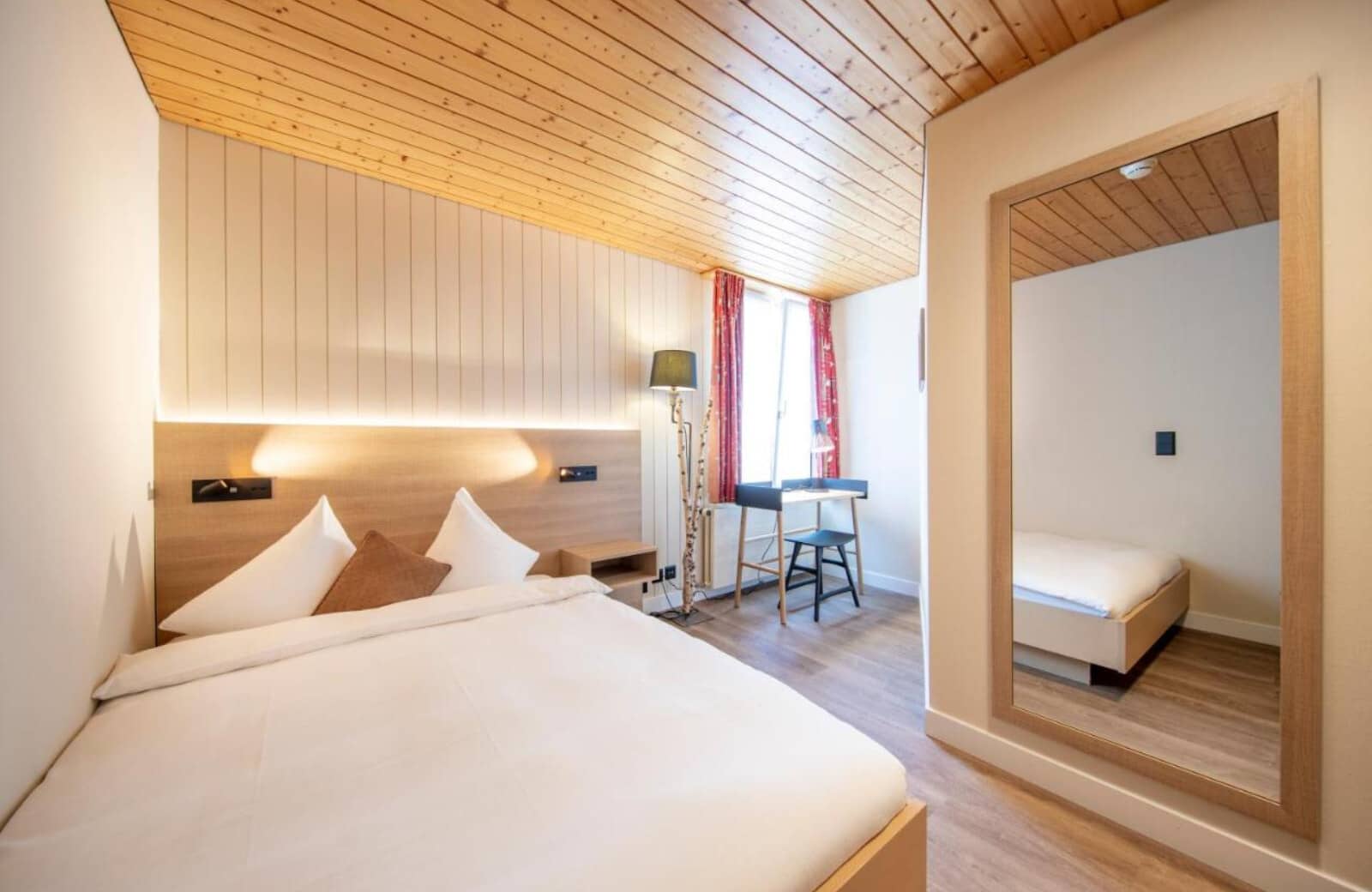 Bedroom with king bed, wood-paneled ceiling, and small workspace desk