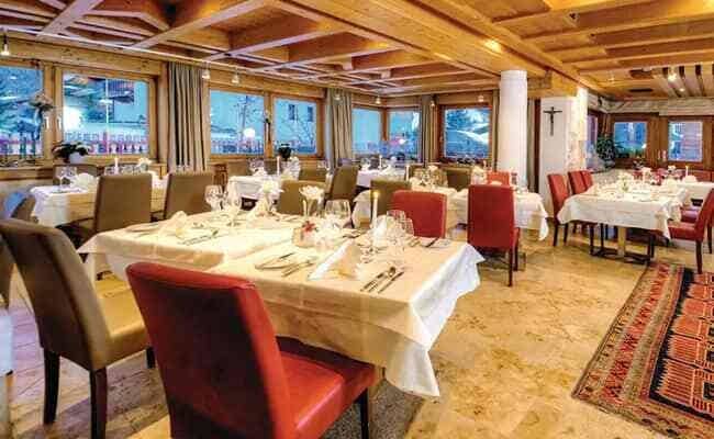 Dining room with white linens and timber coffered ceiling