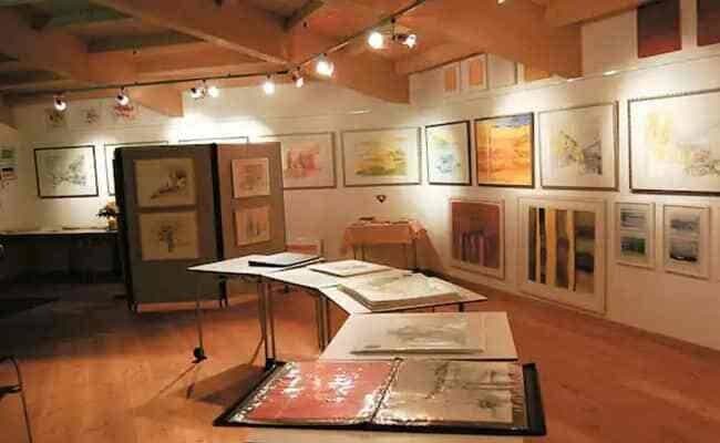 Art studio and gallery space with track lighting and vaulted ceilings