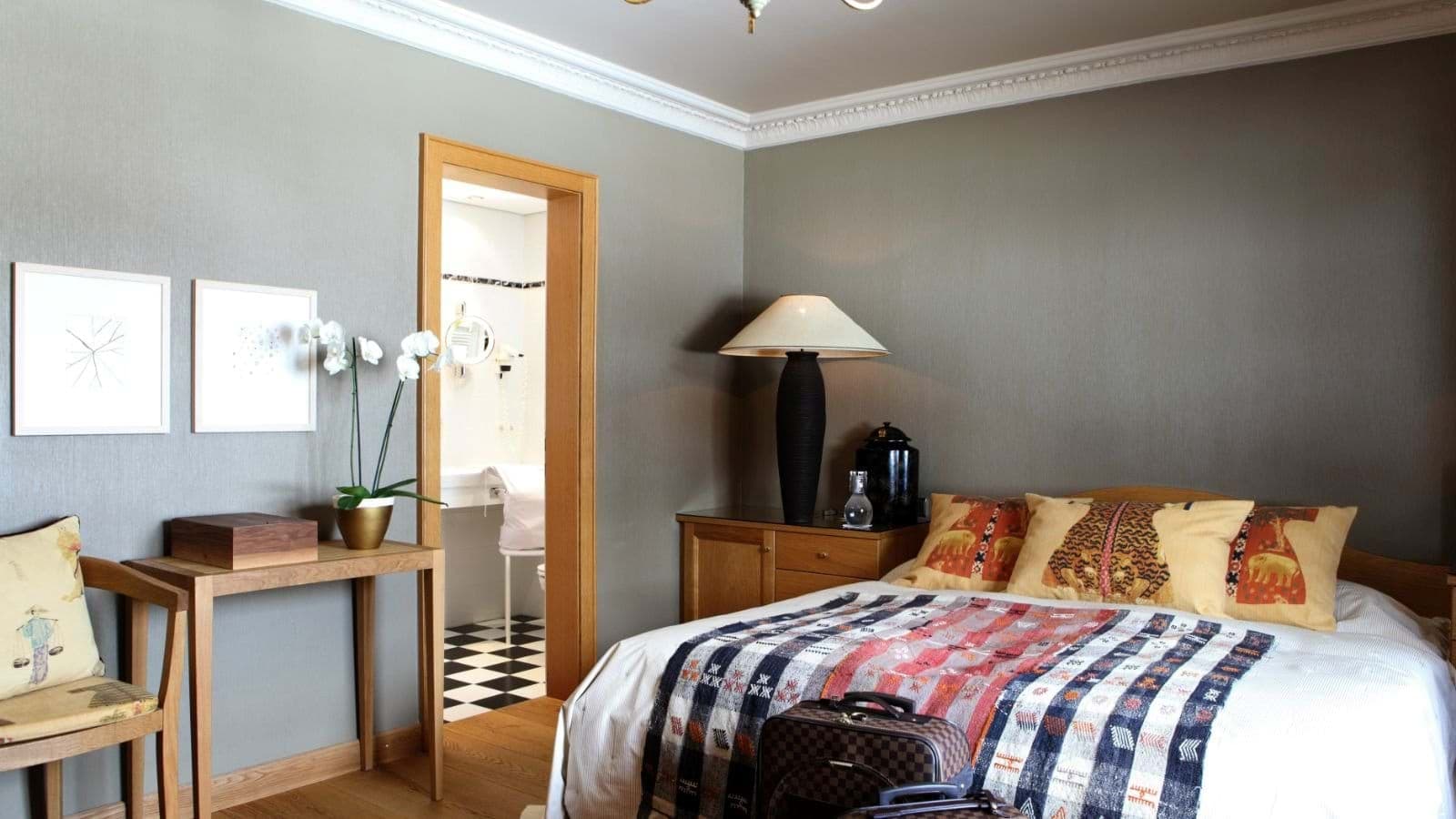 Bedroom with queen bed and ensuite bathroom featuring checkerboard tile