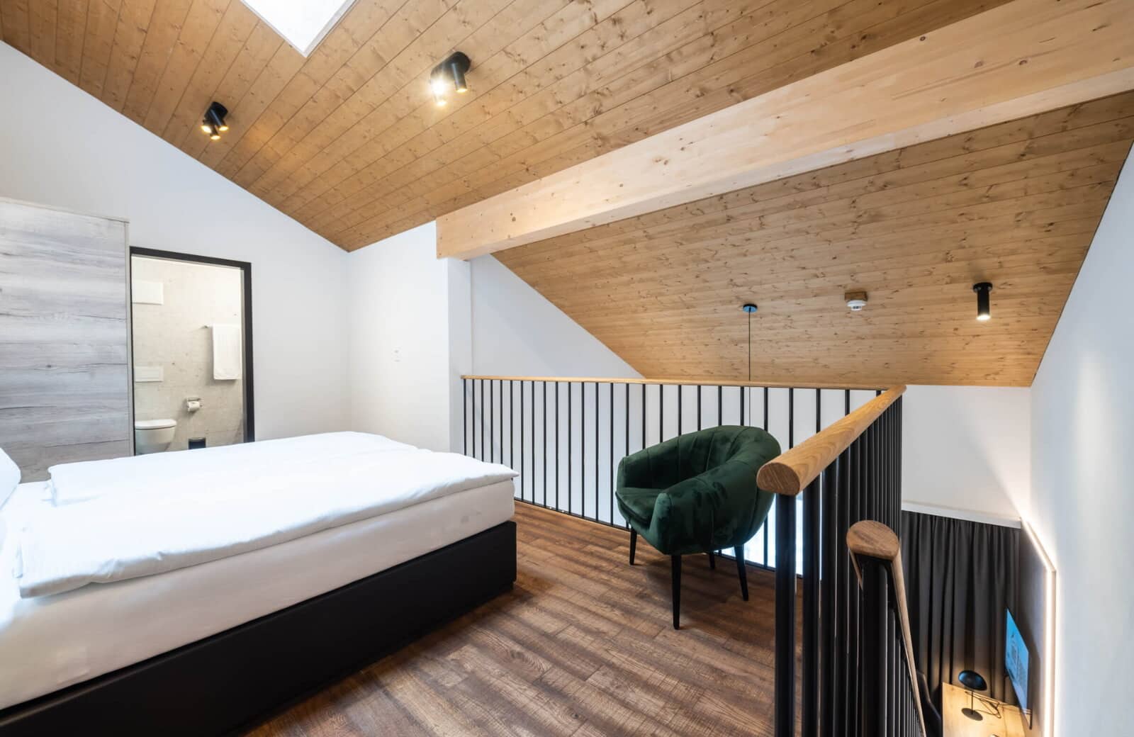 Loft bedroom with ensuite bathroom and vaulted wood ceilings