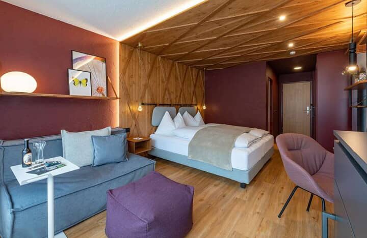 Studio suite with queen bed, seating area, and wood-paneled ceiling