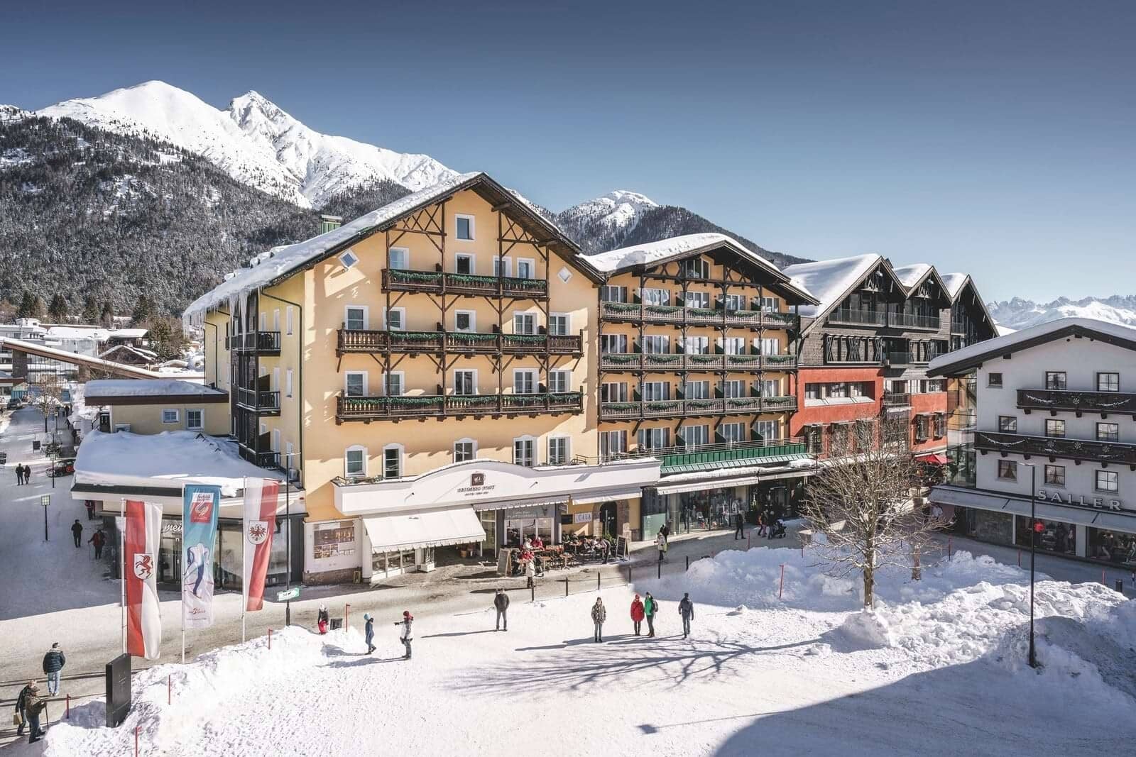 Chalet exterior with ground-floor shops and mountain views; walking distance to slopes
