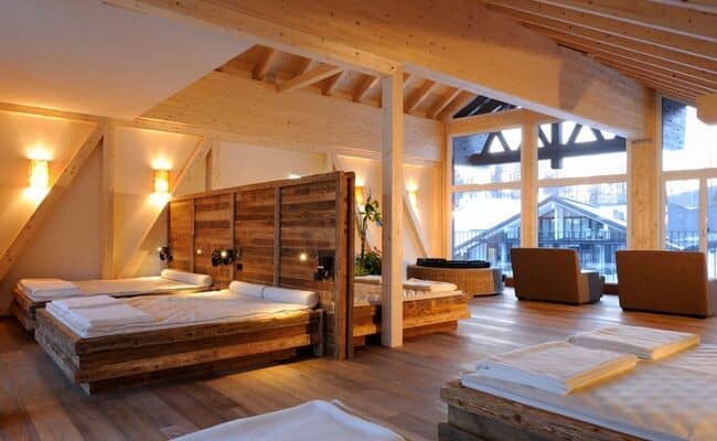 Loft bedroom with four double beds and floor-to-ceiling windows