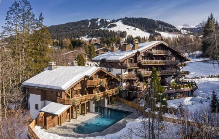 Chalet exterior with heated pool and direct ski slope views