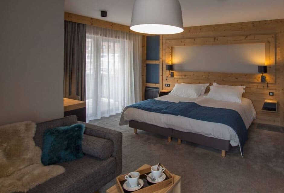 Bedroom with split-king bed, lounge seating, and balcony access