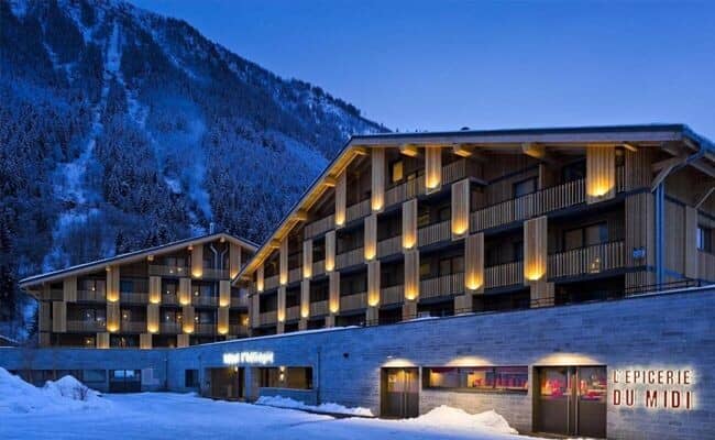 Chalet exterior at dusk with private balconies and on-site grocery shop