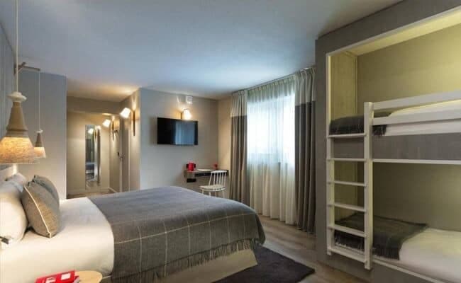 Guest bedroom with queen bed, twin bunks, and built-in desk