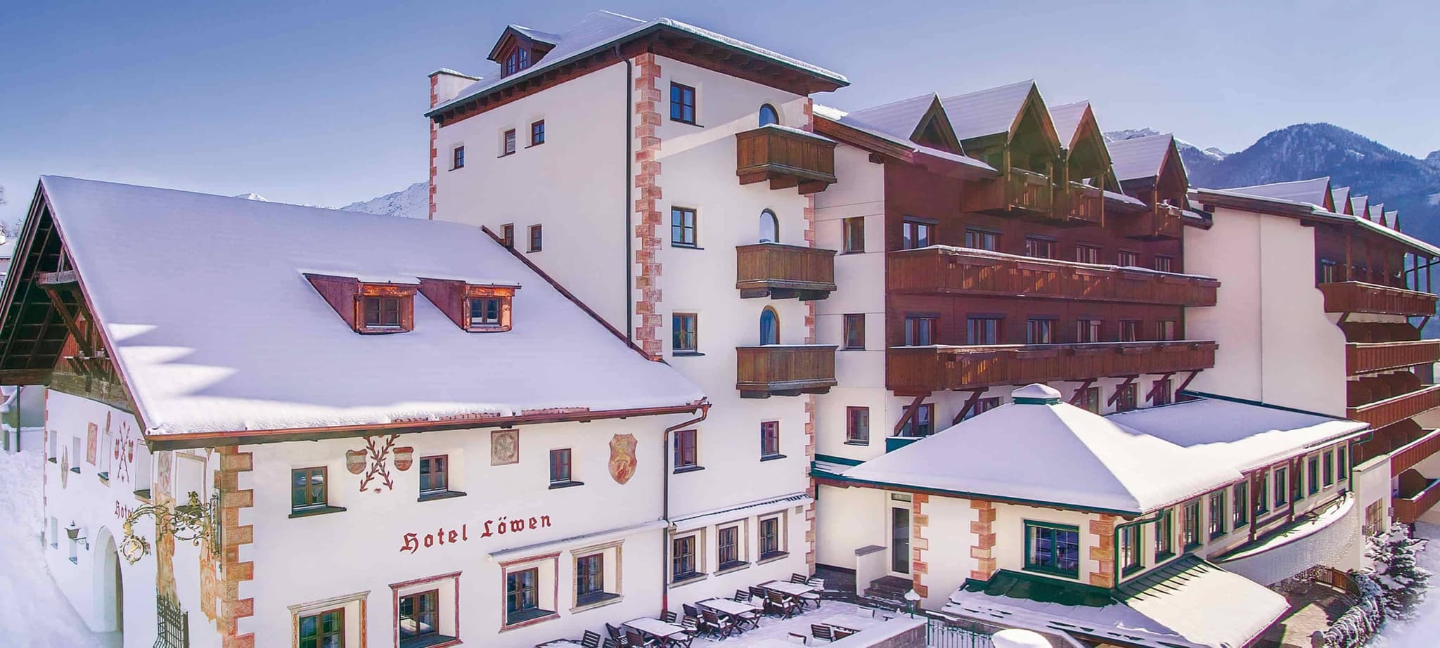 Hotel exterior featuring traditional alpine architecture and private balconies