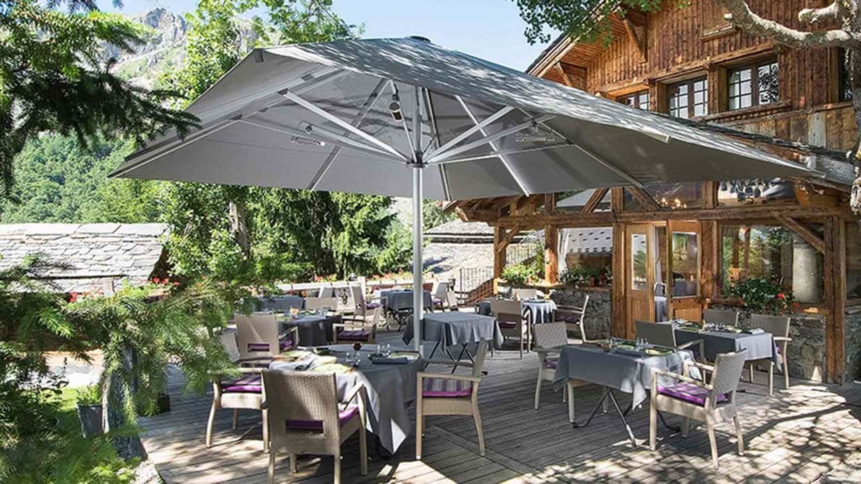 Outdoor dining terrace with mountain views and integrated umbrella heaters