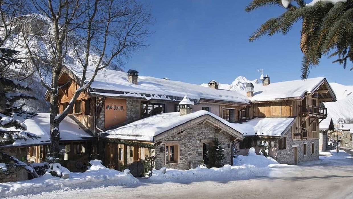 Stone and timber chalet exterior with mountain backdrop