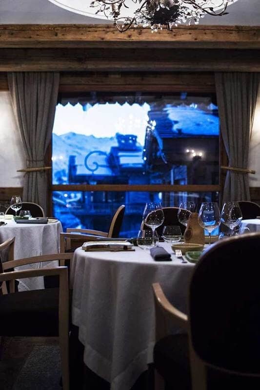 Dining area with large picture window overlooking snow-covered village