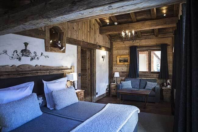 Guest suite with king bed, timber beams, and separate seating area