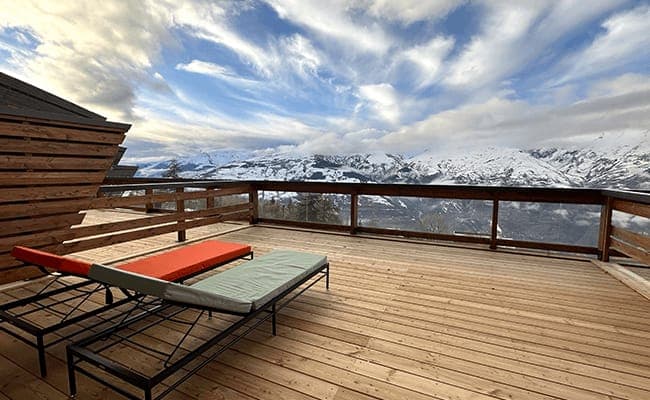 Private sun deck with lounge chairs and panoramic alpine views