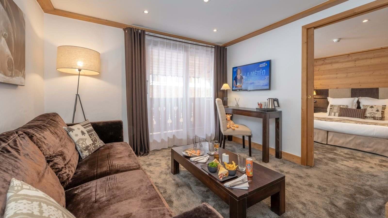 Living area with workspace and sliding door to bedroom