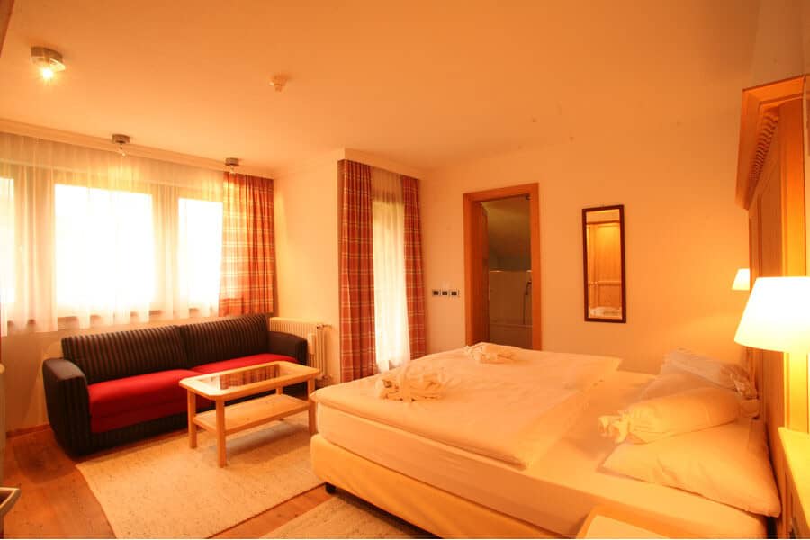 Guest suite with king bed, sofa seating, and ensuite bathroom
