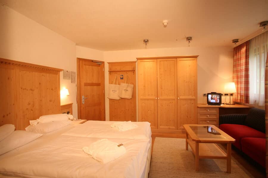 Guest bedroom with twin joinable beds, wardrobe, and sitting area