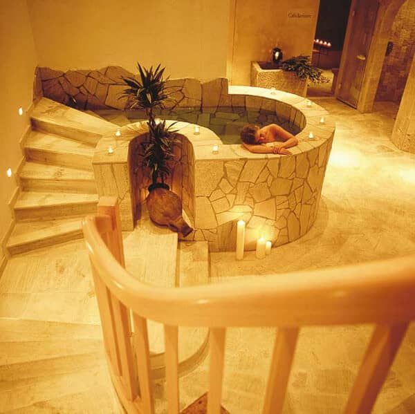 Stone-clad indoor plunge pool with adjacent walk-up stairs and integrated lighting