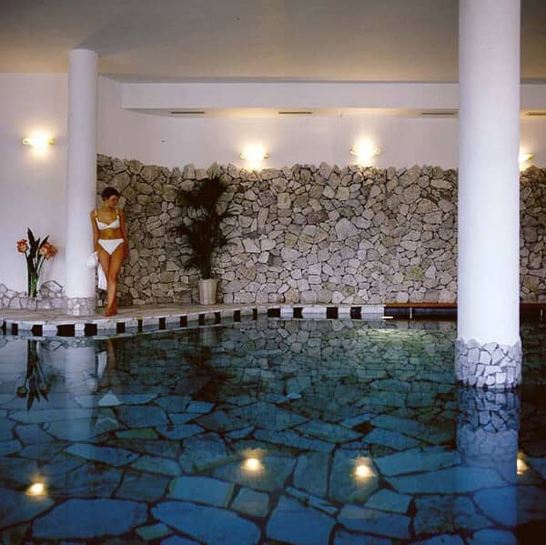 Indoor pool with flagstone flooring and natural stone accent wall