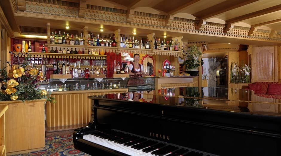 Lobby bar with Yamaha grand piano and hand-carved wood ceilings