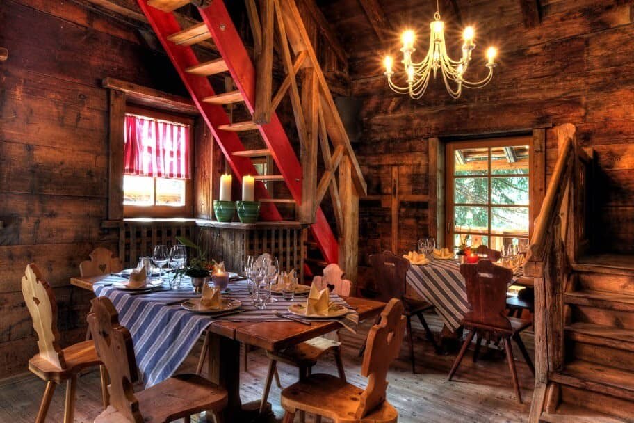 Dining area with dual tables and red ladder stairs to loft
