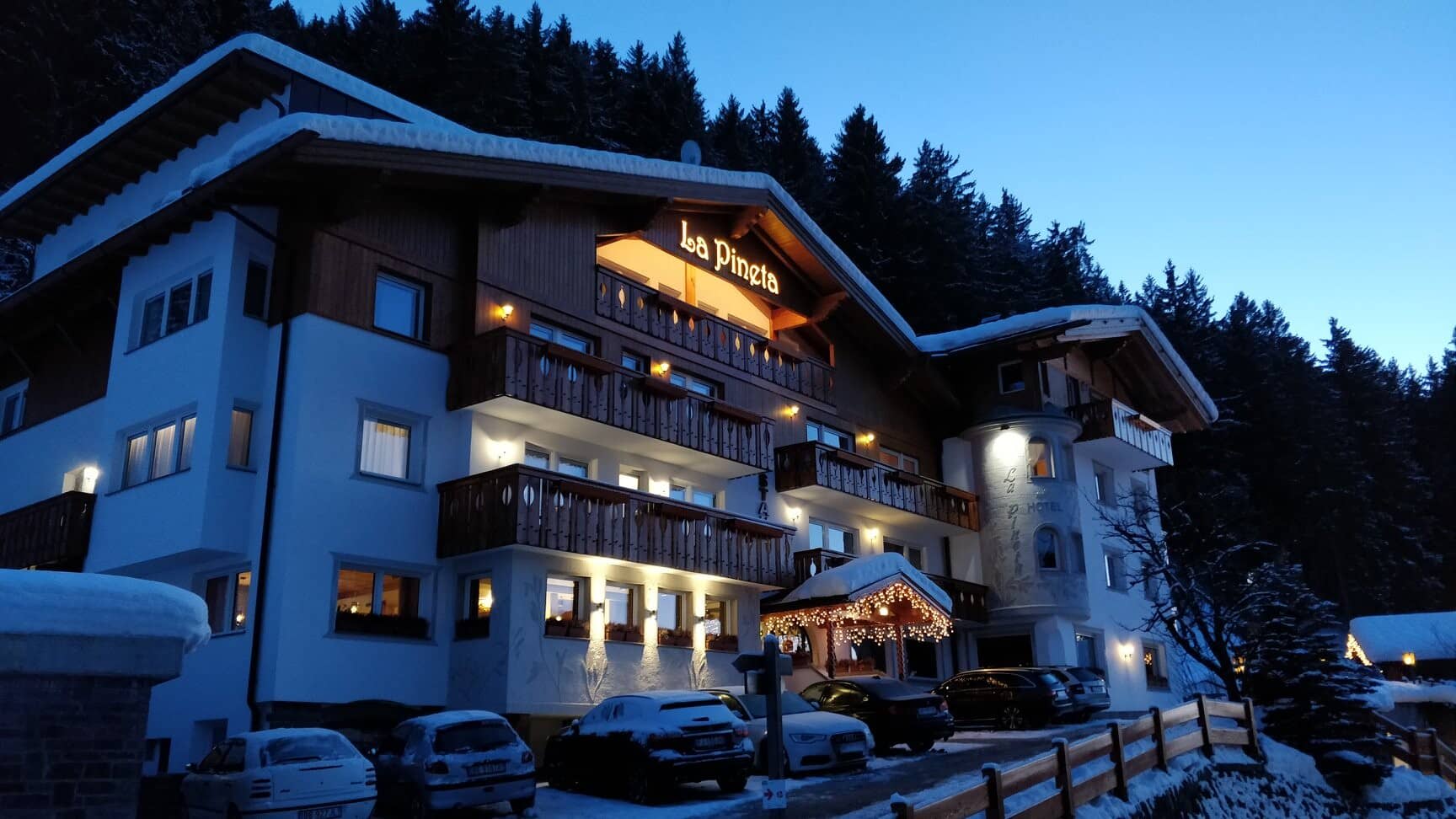 Chalet exterior with private balconies and on-site parking at dusk