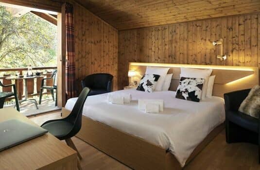 Wood-paneled bedroom with king bed and private balcony access