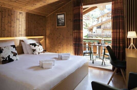 Wood-paneled bedroom with king bed and private balcony access