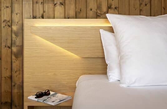Custom headboard with integrated reading light and bedside shelving